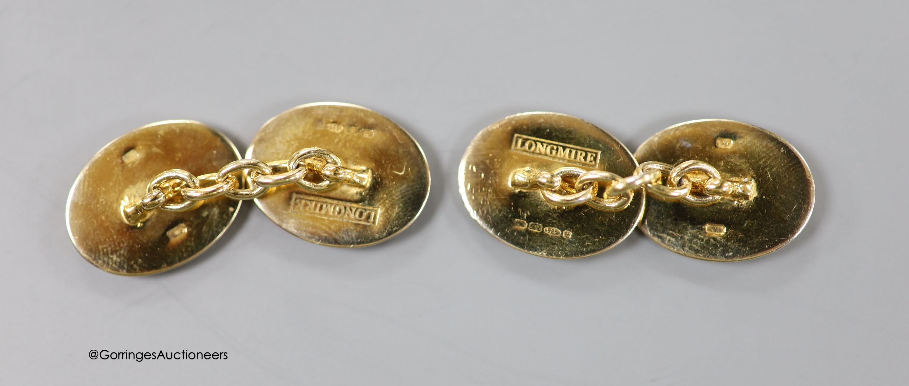 A cased modern pair of silver gilt and enamel Longmire oval cufflinks, decorated with jockey cap and colours, 19mm, gross weight 16.2 grams.